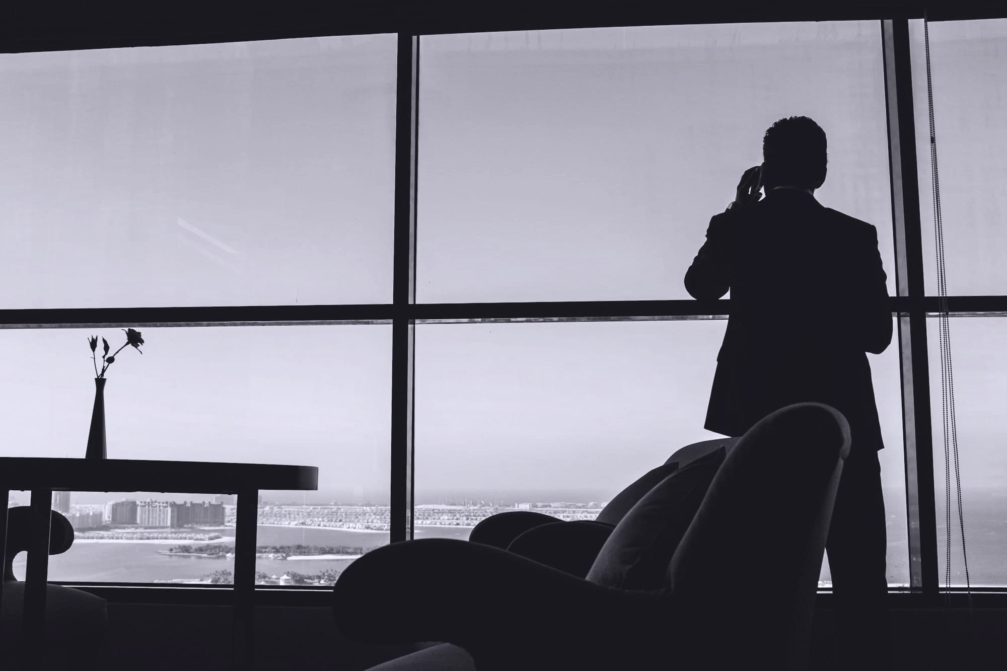 Hombre en un despacho con vistas al mar hablando por teléfono 